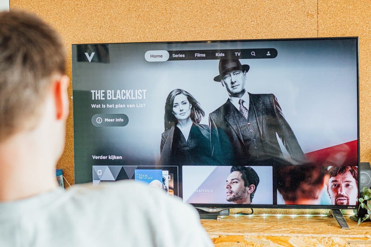 a man looking at a television screen with the show the blacklist on it